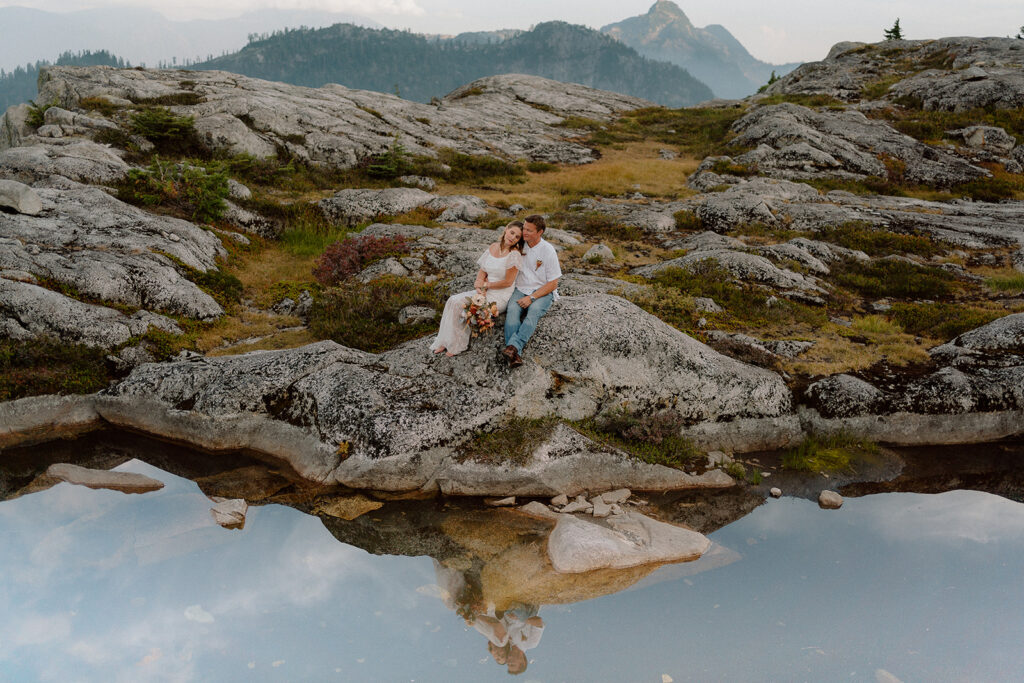couple sitting on a rock at a mountain top