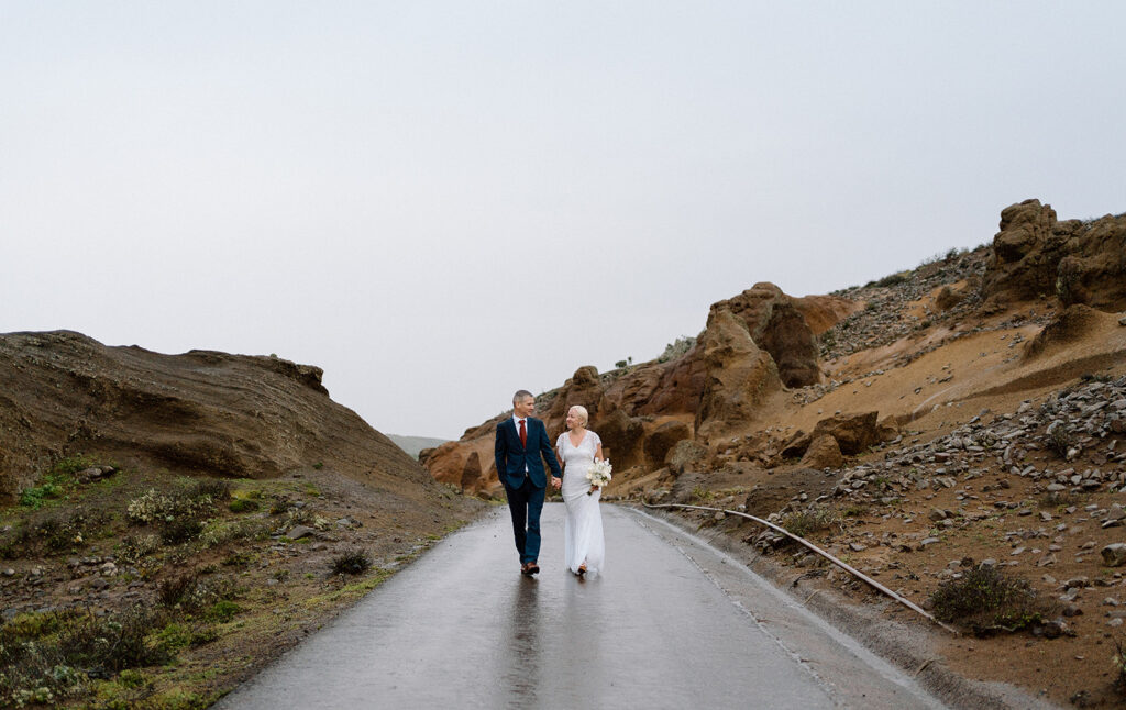 couple holding hands and walking near volcanic scenery in Tenerife