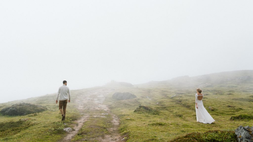 Couple walking separately in their wedding attire at a remote mountain location in Alaska