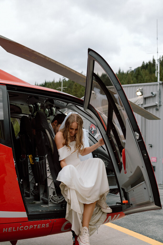 Bride getting out of helicopter during elopement