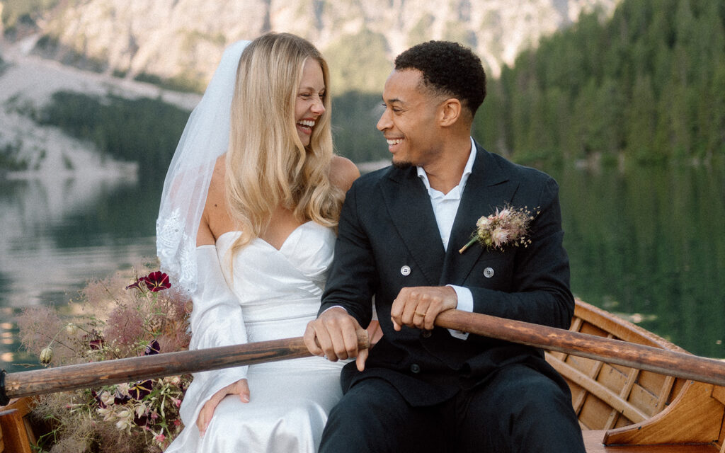 Couple rowing boats during elopement in Lago di Braies Dolomites